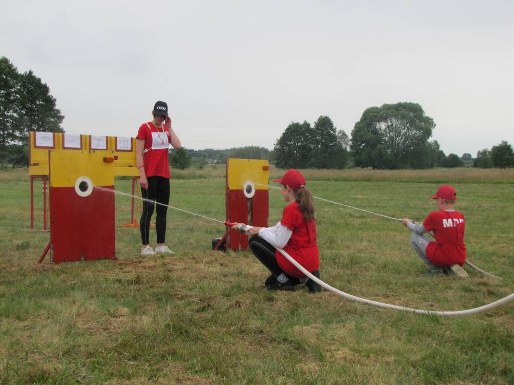 : Zawodnicy MDP Wola Mokrzeska lejący wodę do tarcz nalewnych podczas ćwiczenia bojowego.
